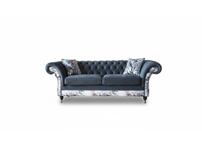 Ein auffälliges Dreisitzer-Sofa im Chesterfield-Design mit zarter grauer Blumendekoration